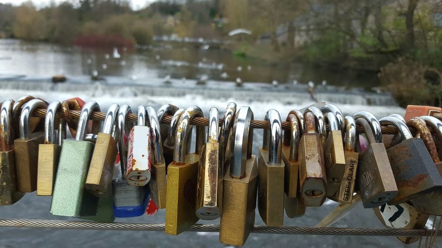 Close-up of love locks on steel cable at bridge over river wye in bakewell