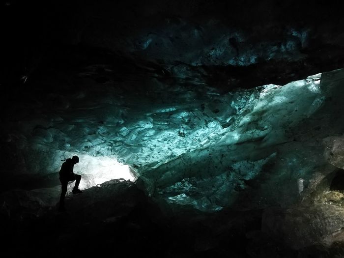 Silhouette woman standing in frozen cave