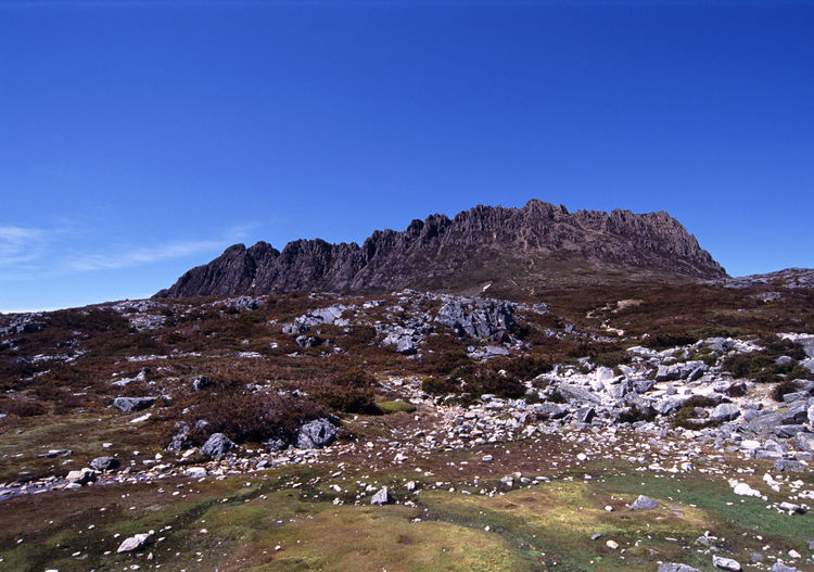 Low angle view of cradle mountain against blue sky