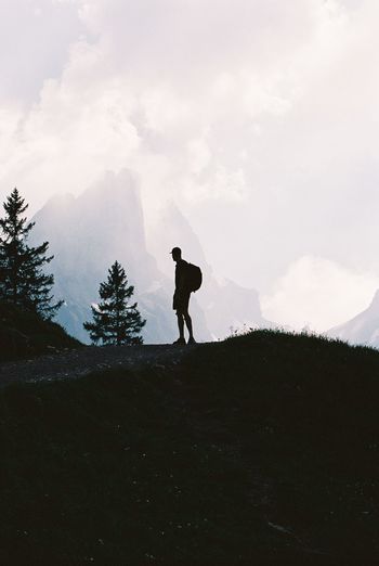 Silhouette man standing on mountain against sky