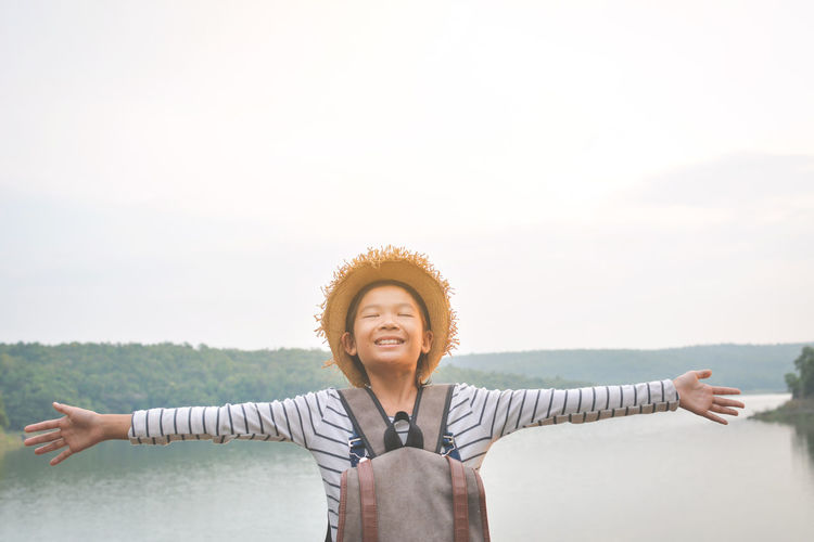 Smiling boy standing against sky