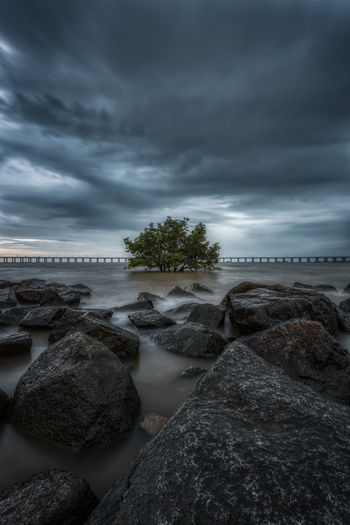 Rocks by sea against sky