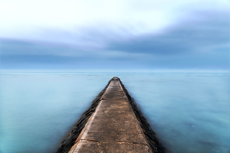 View of pier over sea against cloudy sky