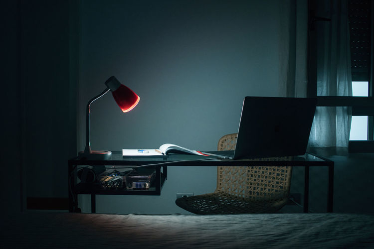 Illuminated electric lamp on table at home