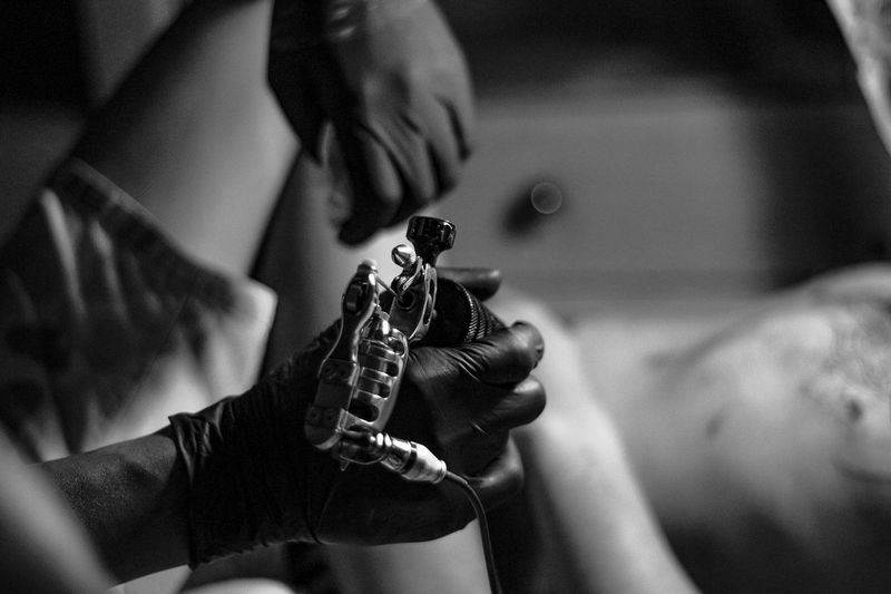 Cropped image of woman holding tattooing machine