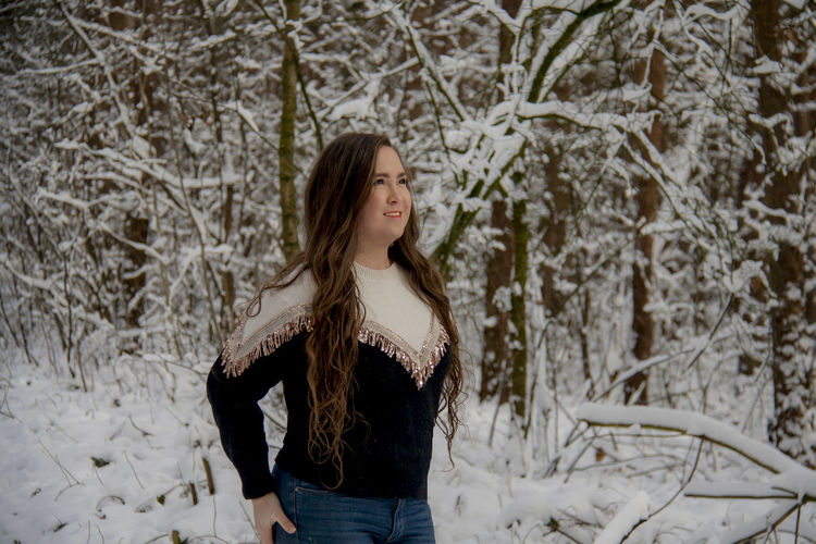 Young woman standing against among snow