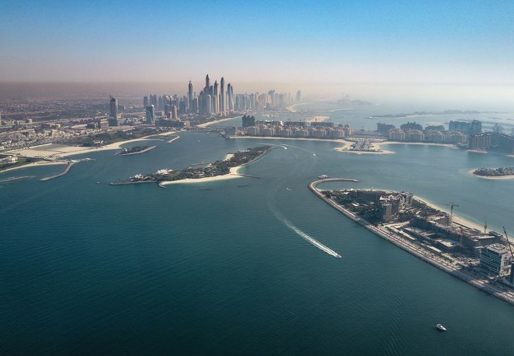 Scenic view of sea by city against sky
