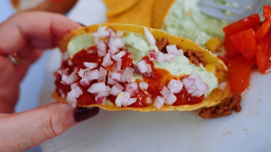 Cropped fingers of woman holding taco