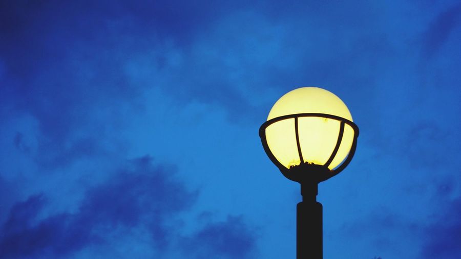 Low angle view of street light against blue sky
