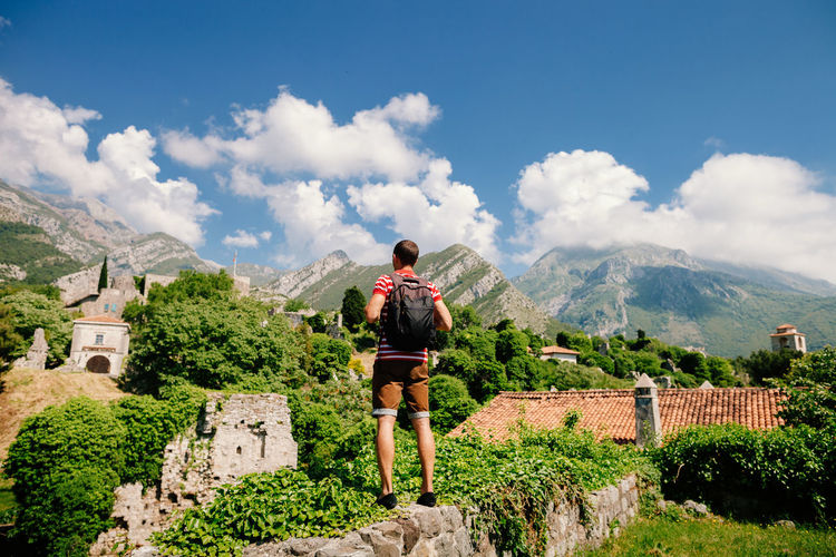Full length of man standing on old ruins against sky