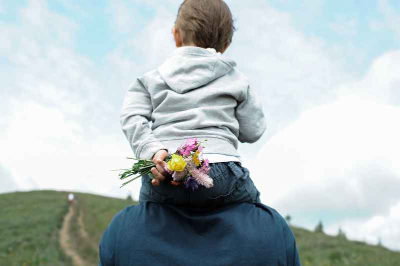 Rear view of father carrying son on shoulders