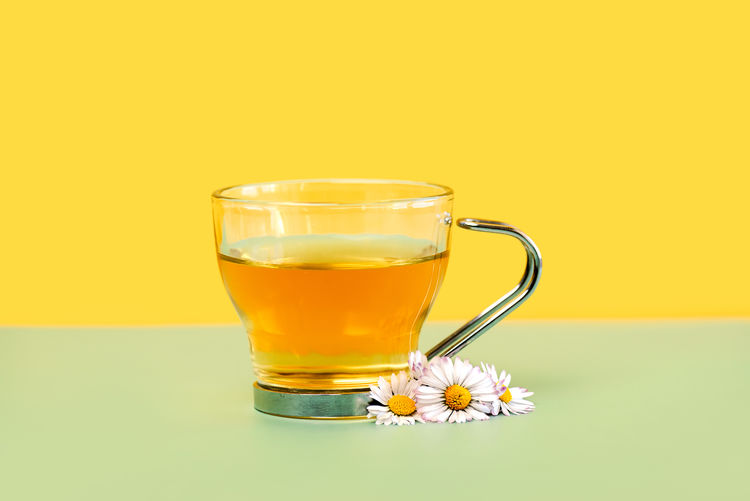 Close-up of drink on table against yellow background