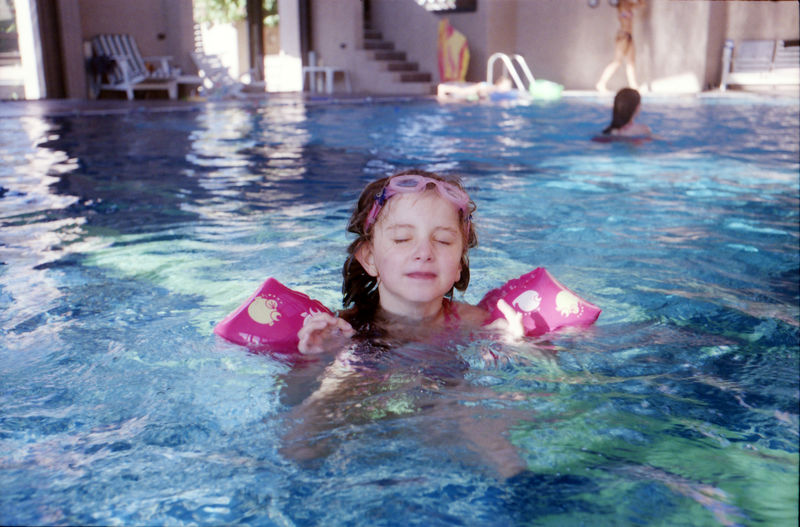 Girl with eyes closed swimming in pool