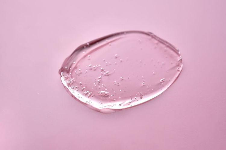 The texture of the cosmetic gel on a pink background.