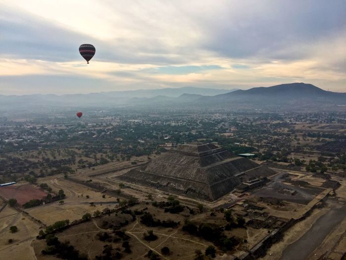 High angle view of hot air balloon flying over city
