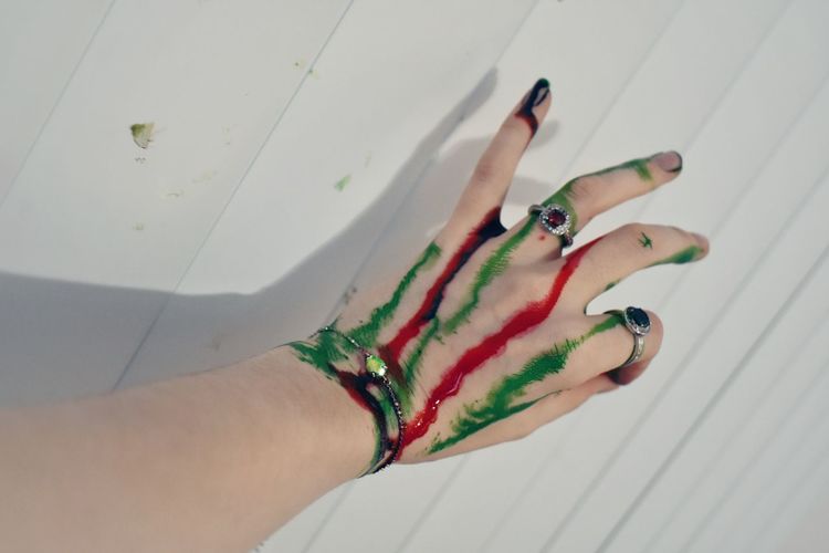 High angle view of christmas color dyed womans hand on white blinds