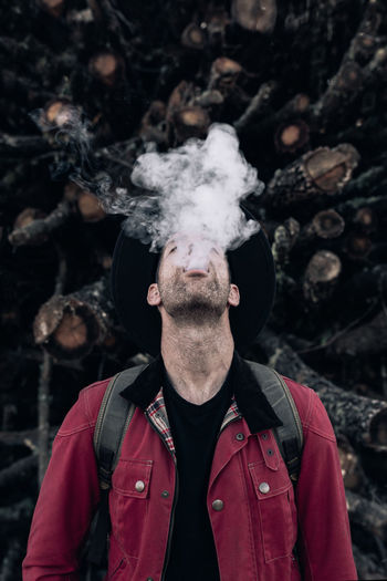 Portrait of young man smoking outdoors