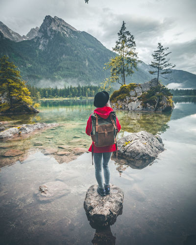 Rear view of woman looking at lake against mountains