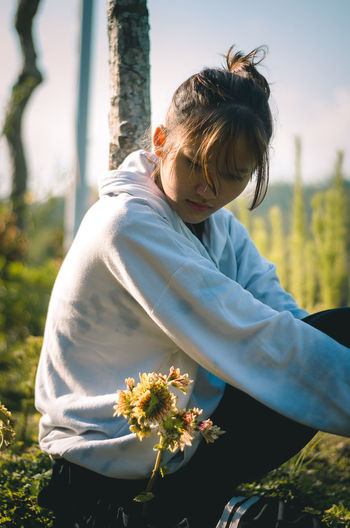 Midsection of woman by flowering plants