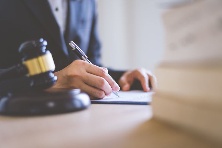Midsection of lawyer writing on paper
