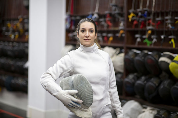 Portrait of woman in fencing outfit at gym