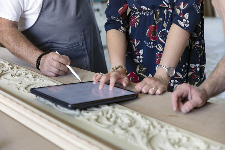Carpenter and designer using digital tablet at workshop