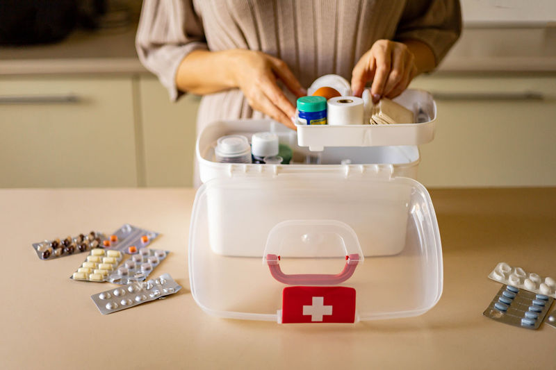 Midsection of woman opening first aid kit