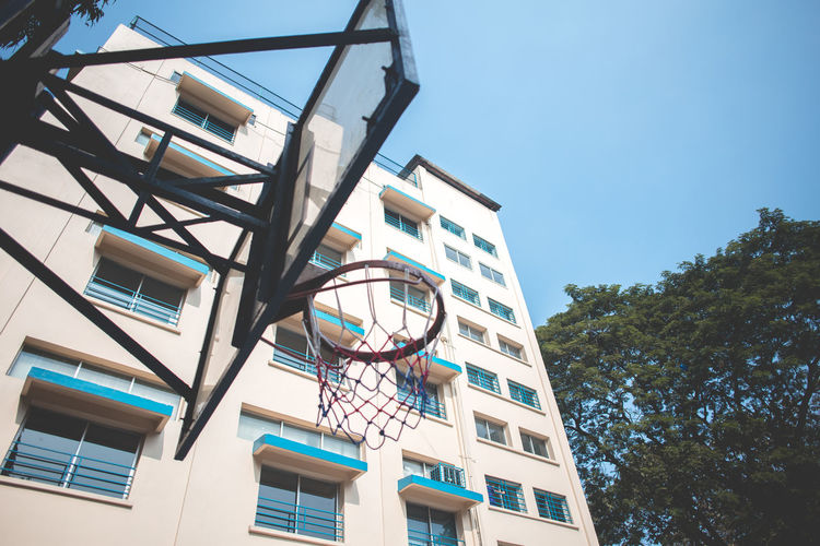 Low angle view of basketball hoop against buildings