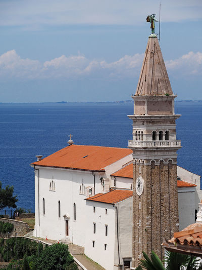 Traditional church by sea against sky