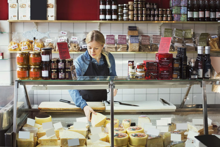 Saleswoman working at display cabinet in supermarket