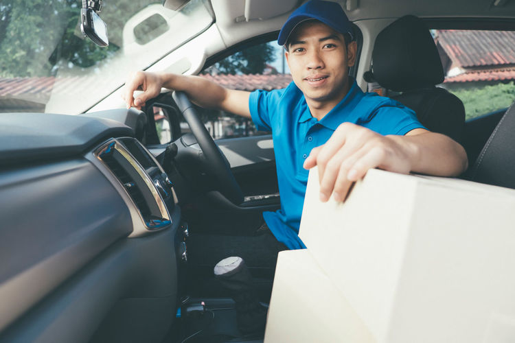 Delivery man with boxes in car